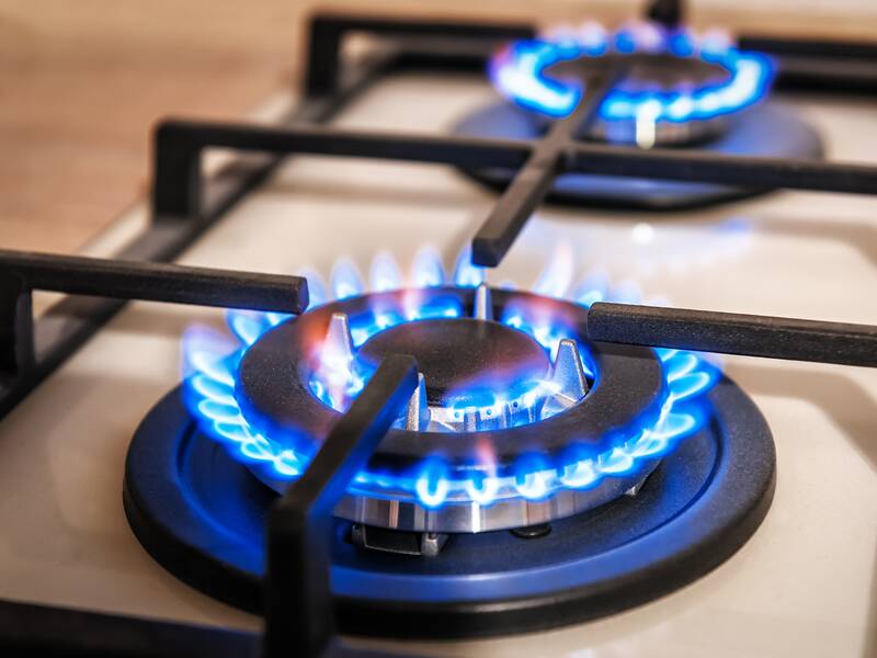 Ein Gaskocher mit zwei Brennern zeigt blaue Flammen.